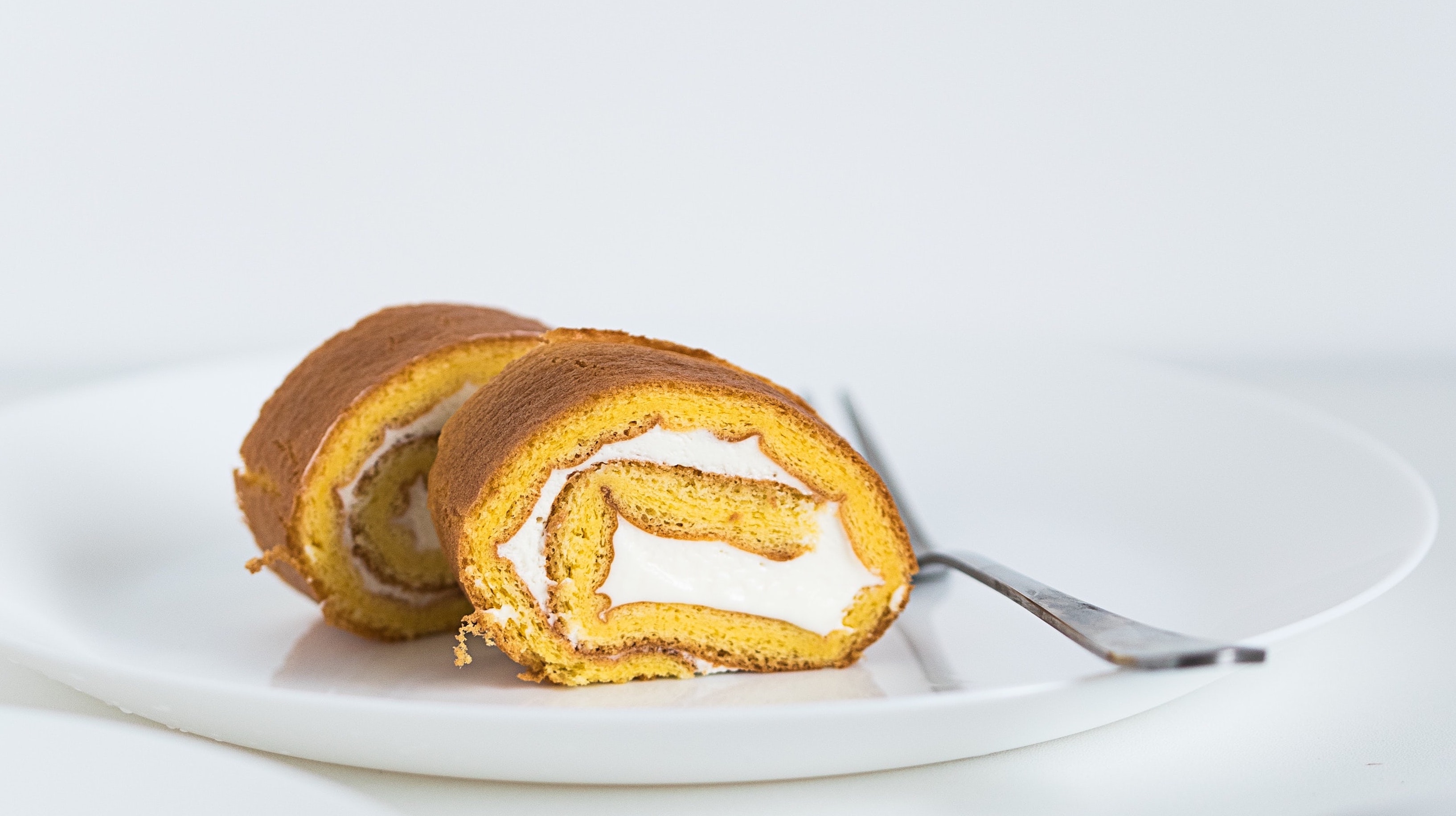 Two Cake Rolls in a plate with a fork nearby